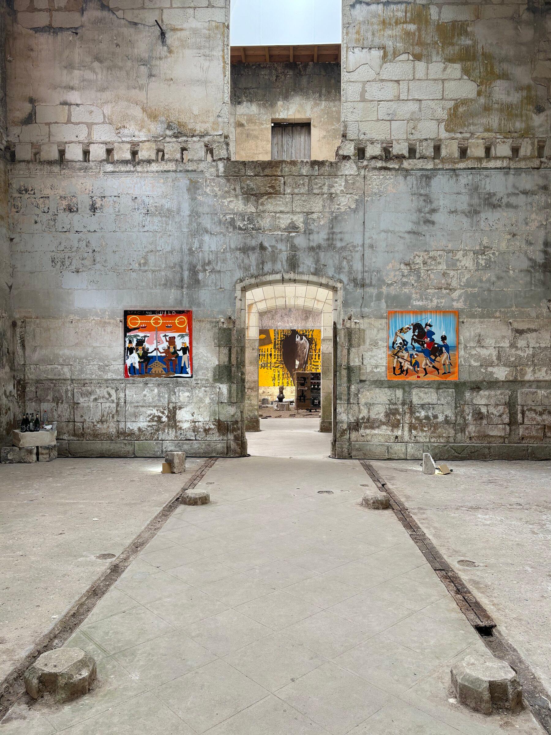A wide installation view of contemporary artworks in the chapel-like space at Château de Montgoger.